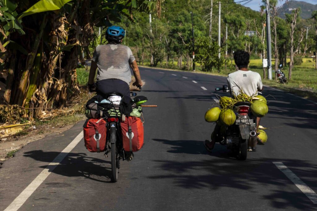Léon op zijn fiets en Indonesische man met kokosnoten op brommer